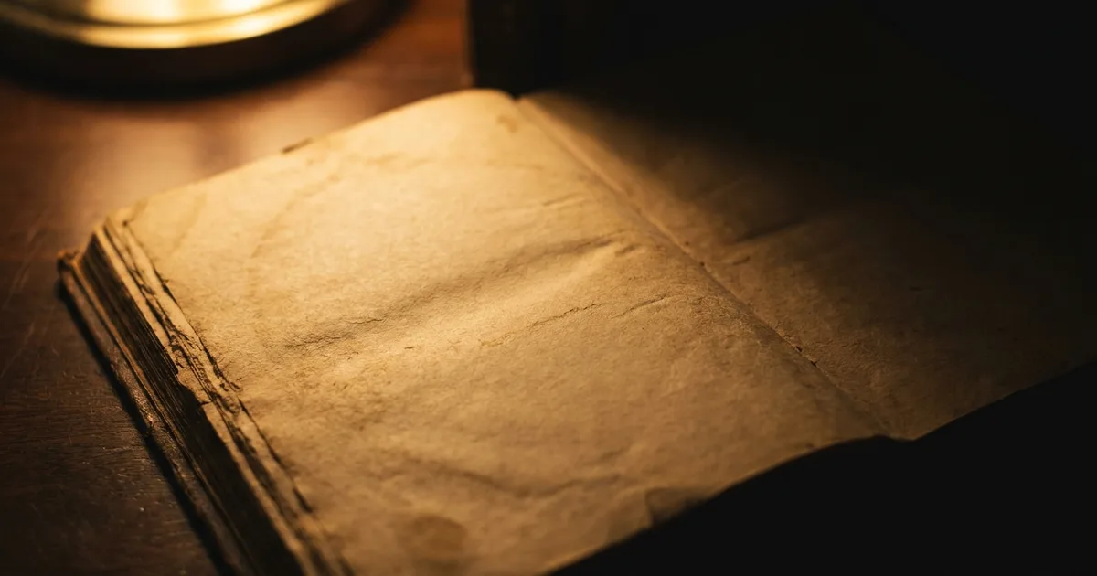 An open antique book on a desk, turned to its copyright page.